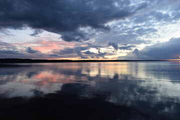 Wall Mural - Dusk sky reflection in lake multicolor shadows sunlight on water