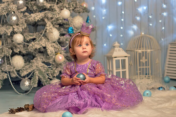 Pretty little girl in smart clothes princess sitting beside Christmas trees