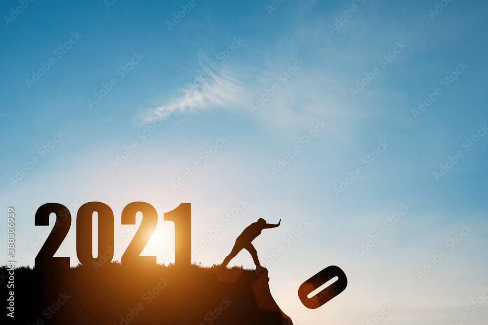 Man push number zero down the cliff where has the number 2021 with blue sky and sunrise. It is symbol of starting and welcome happy new year 2021. - obrazy, fototapety, plakaty 