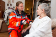 © Katja - a paramedic measures an old woman's blood pressure