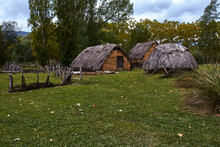 Neolithic Village With Mud Huts And Reeds, In A Meadow Of Green Grass