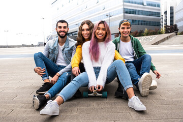 happy group of friend sitting on a skateboard.