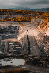 Wall Mural - A industrial lime stone quarry in the mountains with beautiful autumn colors on a wind dramatic day