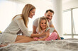 © Drpixel - Happy family having fun at home. Young parents with daughter using digital tablet