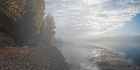 Wall Mural - panoramic view of autumn foggy morning on the river, bright colorful trees, fallen leaves and reflec