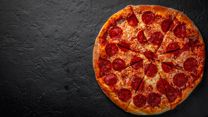 Pepperoni Pizza with Mozzarella cheese, salami, Tomato sauce, pepper, Spices. Italian pizza on Dark grey black slate background