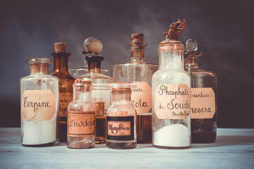 closeup of ancient apothecary pots with ingredients for medicine isolated over dark background 