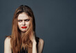 © SHOTPRIME STUDIO - woman with red lips and in a black sundress on a gray background touches her face with her hands