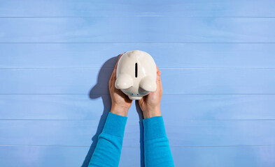 Wall Mural - Person holding a piggy bank from above