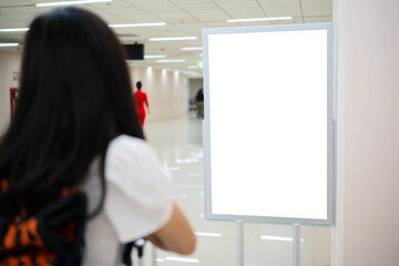 Asian women tourists stand and watch the billboards. A blank billboard to put text