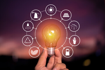 Wall Mural - ecology concept. power energy in nature. hand holding lightbulb with solar with icons energy sources
