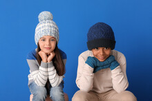 Cute Children In Winter Clothes On Color Background