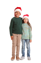 Wall Mural - Cute children in winter clothes and Santa hats on white background