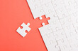 © sorapop - Top view flat lay of paper plain white jigsaw puzzle game texture last pieces for solve and place, studio shot on a red background, quiz calculation concept