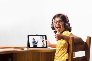 Indian girl studying using laptop or tablet during home schooling - online learning concept