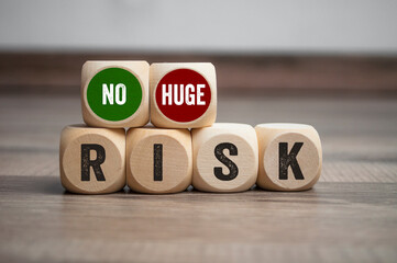 Cubes, dice or blocks with no risk or huge risk on wooden background