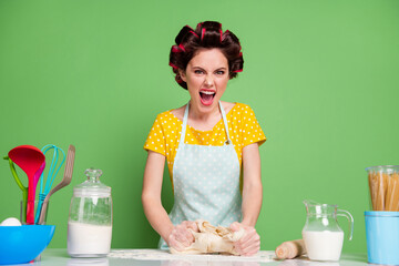 Wall Mural - Portrait of her she nice attractive glamorous angry fury mad irritated housewife cooking kneading dough on table desk screaming learning workshop isolated over green pastel color background