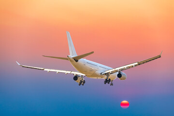 Wall Mural - Commercial airplane flying above clouds in colorful sunset.Travel,holidays and business concept.