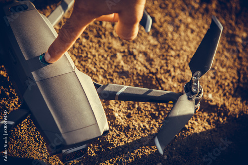 Cuadros en Lienzo Drone on the ground with a hand touching it