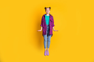 Poster - Full length photo of pretty nice charming teen lady jump high up excited good mood street look rejoicing wear casual plaid shirt sneakers jeans isolated yellow vivid color background