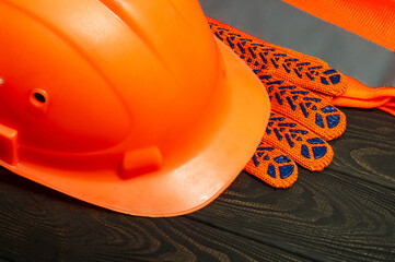 Master builder's orange protective equipment stacked on black boards before work