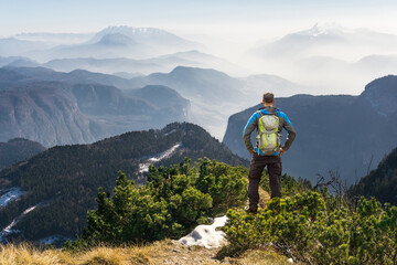 Man hiking on mountain trail. Great view above the clouds and fog.