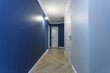 © hiv360 - Empty unfurnished corridor with minimal preparatory repairs with crown moulding. interior of white and blue walls