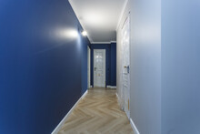 Empty Unfurnished Corridor With Minimal Preparatory Repairs With Crown Moulding. Interior Of White And Blue Walls
