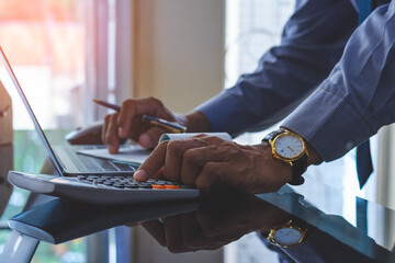 Wall Mural - Business man hand using calculator and sign cheque.