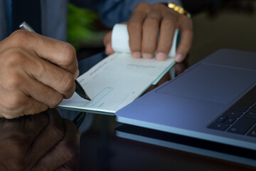 Wall Mural - Business man hand sign cheque book.