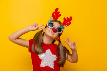 Little girl wearing party glasses with reindeer antlers