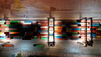 Aerial drone night shot of illuminated loading/unloading container terminal in commercial port of Perama, Piraeus, Attica, Greece