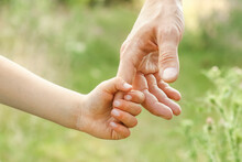 Hands Of Parent And Child In Nature