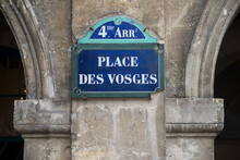 Closeup Of Place Des Vosges Street Name On The Traditional Parisian Street Plate On Stoned Building