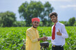 © PRASANNAPIX - indian farmer and banker standing at field