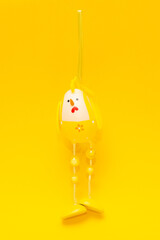 Easter chicken hanging on yellow background