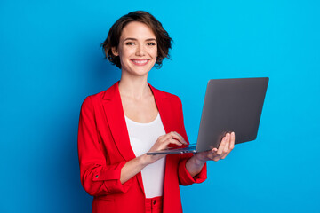 Sticker - Portrait of attractive cheerful skilled businesslady holding in hand laptop isolated over bright blue color background