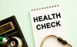 © Ihar - Notepad with text HEALTH CHECK, calculator and stethoscope. Medical concept.
