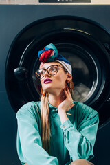 Wall Mural - stylish young woman in glasses and turban in laundromat