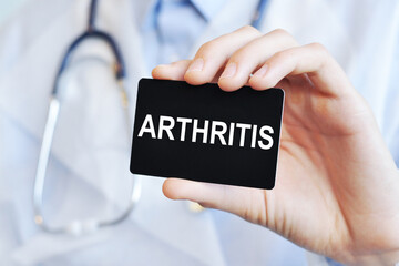 Doctor holding a paper card with text ARTHRITIS, medical concept