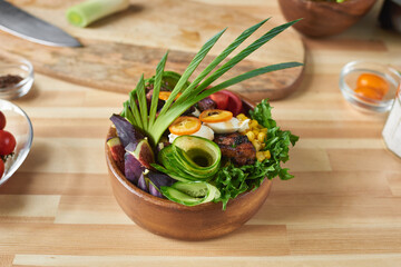 Wall Mural - Image of bowl with fried meat and fresh vegetable decorated with lettuce leaves from chef on the table