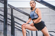 Cropped photo of 20s beautiful female sportsman stretching on the stairs outdoors