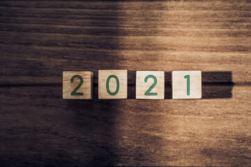Aufkleber - 2021 happy new year on wood block on wood table and concrete wall with sunlight from window.hope new year concept