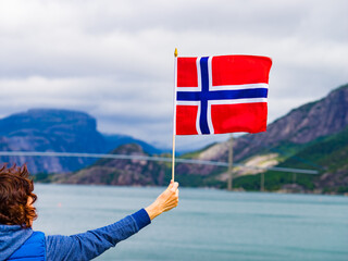 Canvas Print - Tourist with norwegian flag on fjord