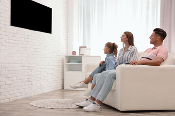 Poster - Happy family watching TV on sofa at home