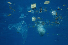 Plastic And Other Debris Floats Underwater In Blue Water. Plastic Garbage Polluting Seas And Ocean