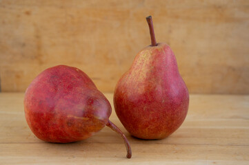 Two pears edible fruits, tasty ripened red yellow fruit on wooden background