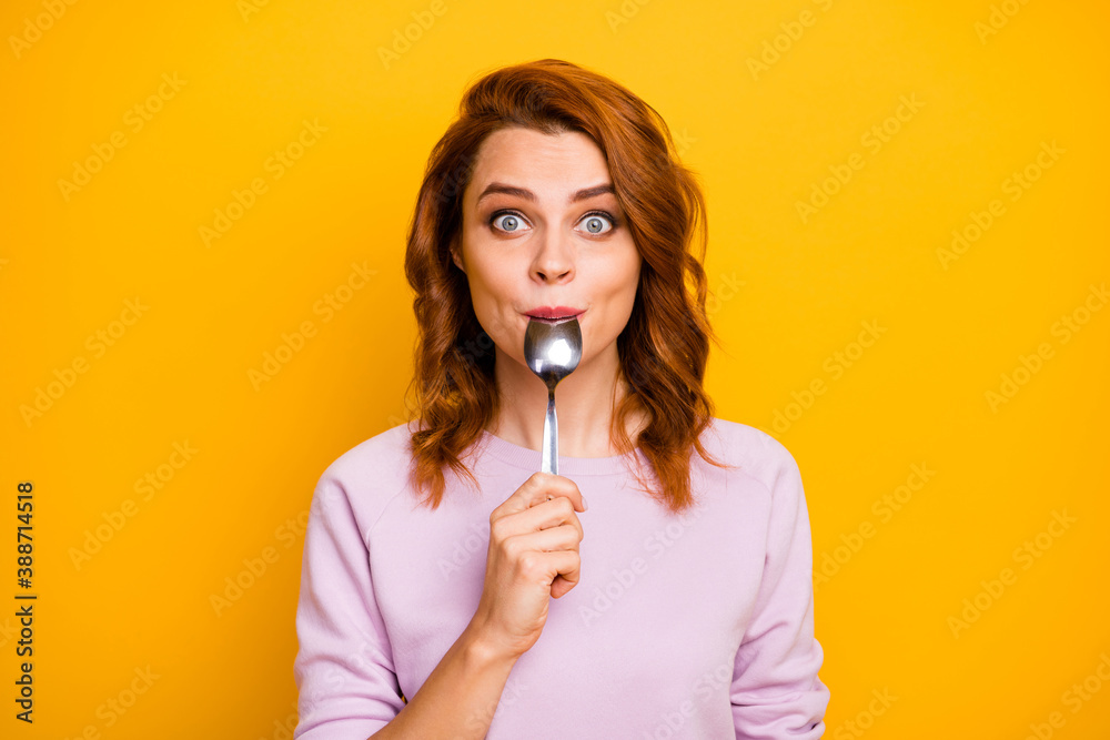 Portrait of astonished inspired girl have weekend in restaurant taste dish enjoy lick spoon impressed stare stupor wear pink jumper isolated over yellow color background - obrazy, fototapety, plakaty 