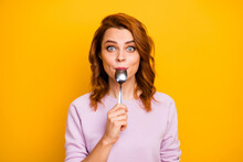 Portrait Of Astonished Inspired Girl Have Weekend In Restaurant Taste Dish Enjoy Lick Spoon Impressed Stare Stupor Wear Pink Jumper Isolated Over Yellow Color Background