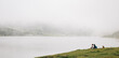 © FranTc - People sitting in front of the foggy lake on the peaks of Europe